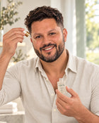 El modelo masculino aplicándose Sérum Glow en el rostro