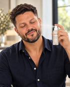 El modelo masculino aplicándose Tónico facial en el rostro